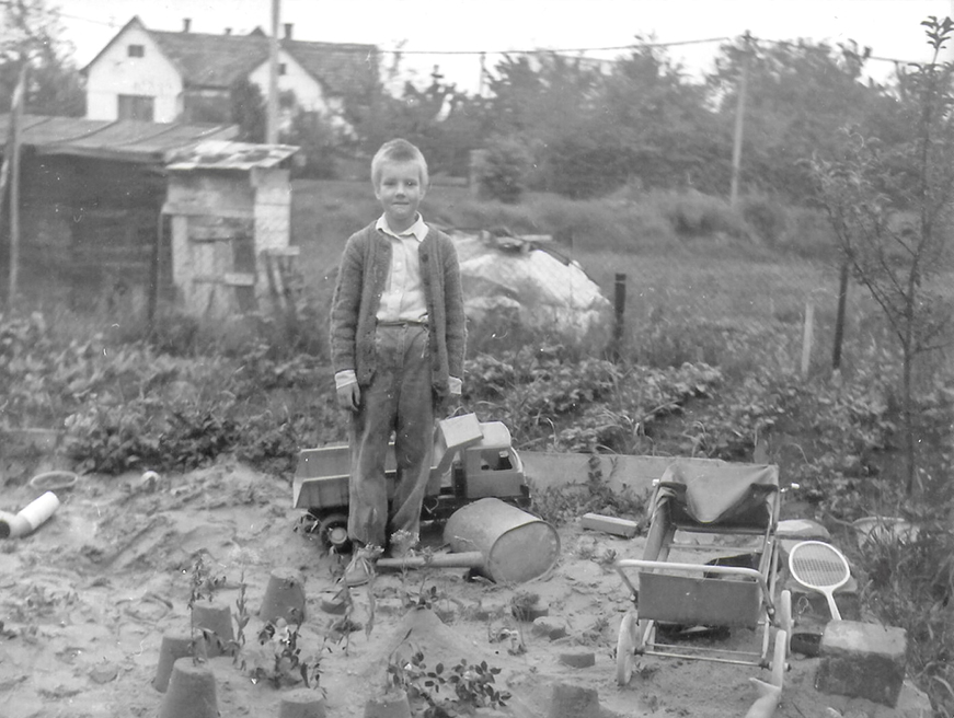A childhood photo of me, playing in the sand in our family garden, 1980s