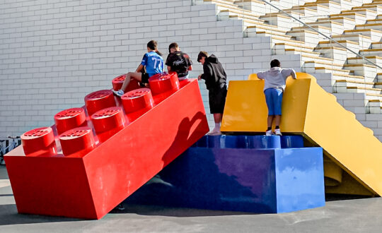 Giant Lego bricks with kids climbing up on them, in front of the LEGO House, Billund, Denmark