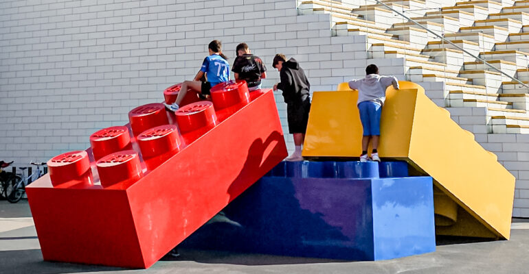 Giant Lego bricks with kids climbing up on them, in front of the LEGO House, Billund, Denmark